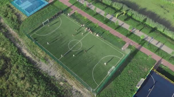 Футбольное поле на открытом воздухе. Люди играют в футбол в солнечный летний день. Спортивная площадка — стоковое видео