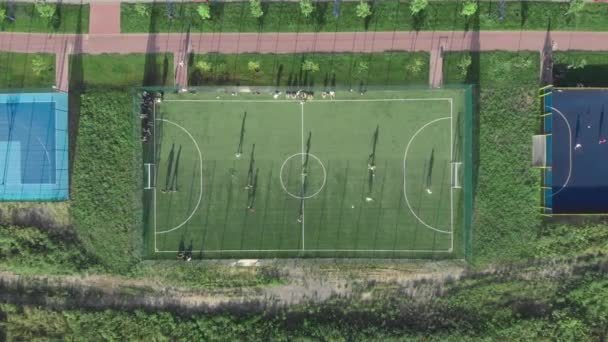 สนามฟุตบอล สนามฟุตบอลสีเขียวด้านนอก คนที่เล่นเกมกีฬาในสนามเด็กเล่นกีฬา — วีดีโอสต็อก