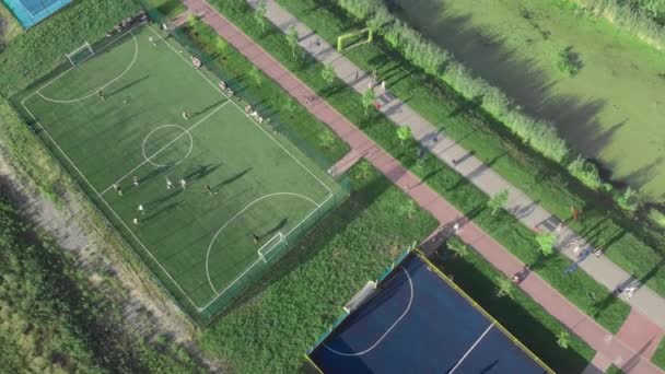 Gente jugando fútbol en el patio de recreo deportivo. Mini campo de fútbol deporte al aire libre — Vídeos de Stock