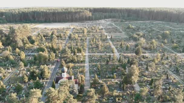 Begraafplaats met graven. Drone vloog over oude begraafplaats bij zonsopgang. Begraafplaats met kerk — Stockvideo