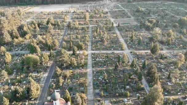 View over headstones at cemetery. Graveyard with graves and church — Stock Video