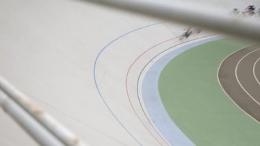 Bir grup profesyonel bisikletçi Velodrome 'da şampiyonluk yarışına katılıyor.