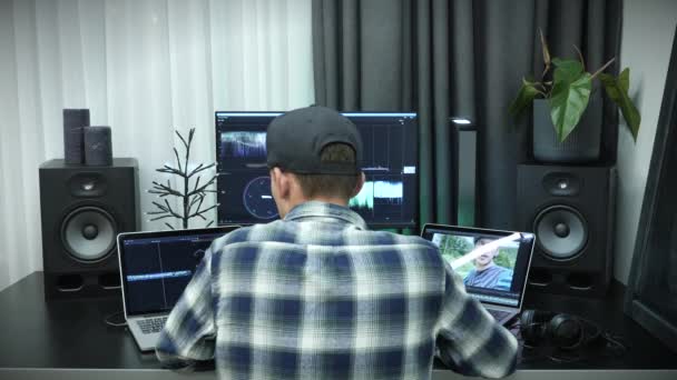 Man editing beeldmateriaal op post productie software op de computer met grote display. Kleurcorrectie aan de gang — Stockvideo