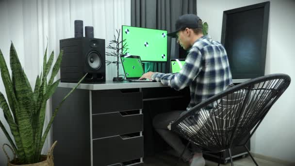 Man die op computer met groot vertoning met groen chroma zeer belangrijke scherm werkt, typend op toetsenbord — Stockvideo