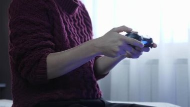 Kız TV 'de video oyunu oynamak için kumanda kullanıyor. Ev etkileşimli video oyun konsolu