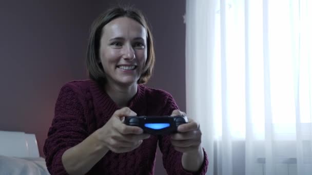 Garota excitada jogando e ganhando em videogame online. Mulher joga no joypad sem fio — Vídeo de Stock