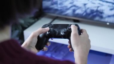 Ev etkileşimli video oyun konsolu. Video oyunları oynamak için denetleyici kullanan kişi