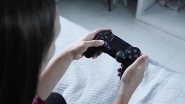 Eller elektronik oyunda joystick kullanır. Kablosuz denetleyici ile video oyunu oynayan kız