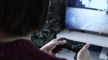 Konsolda video oyunları oynuyorum. Heyecanlı kız kablosuz kontrolörle video oyunu oynuyor