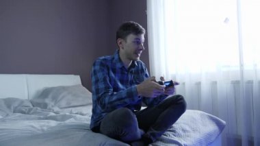 Oyun konsolu tutan adam joystick 'i kontrol ediyor, evde oyun oynuyor