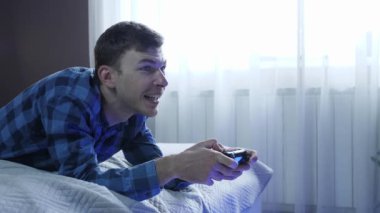 Video oyun konsolu. Elinde kablosuz joystick tutan adam video oyunları oynuyor.