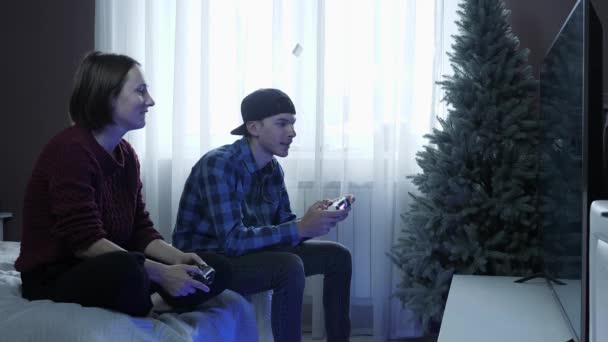 Feliz casal animado jogando videogames no console. Amigos brincam com controle sem fio em casa — Vídeo de Stock