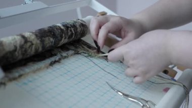 Kadın elleri çapraz dikiş dikiyor. Hobiler ve el işi. Kadın nakış işliyor.