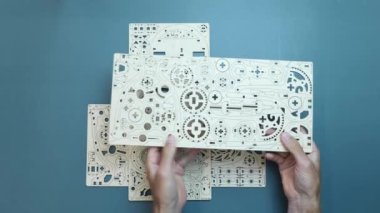 Elinde tahta yapboz çarşaf oyuncağı tutan adam kameraya gösteriyor. Evde oyun etkinliği