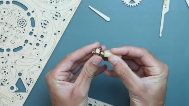 Mechanisch houten puzzelstuk. Handen vasthouden van kleine houten stukjes puzzelspeelgoed — Stockvideo