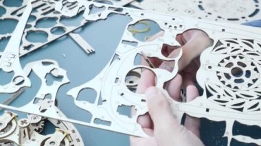 Küçük detayları ve çarkıfeleği olan mekanik ahşap oyuncaklar. Eller yapboz oyuncağını monte etsin