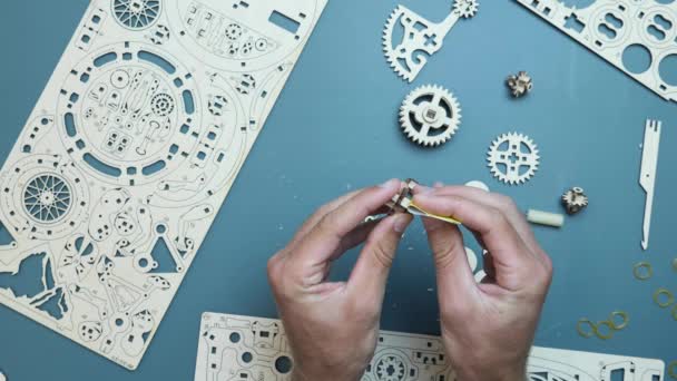 机械木制拼图玩具。手握小玩具细节，组装机械齿轮玩具 — 图库视频影像