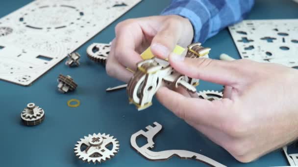 Man die schuurpapier gebruikt om houten puzzels te maken. Mechanisch speelgoedje. Spel concept — Stockvideo