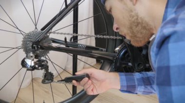 Tamirci bisiklet zinciri kayganlaştırıcıyı bisiklet atölyesinde özel kayganlaştırıcı ile kayganlaştırır