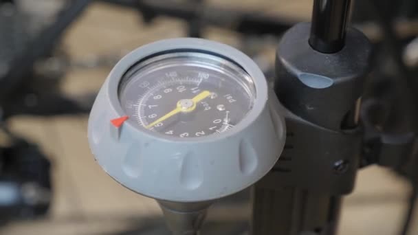 Hand bicycle pump with visible pressure. Bicycle mechanic pumping bike wheel tire — Stock Video