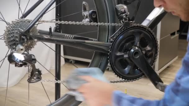 Bike maintenance. Bicycle mechanic cleaning bike chain with microfiber cloth — Stock Video