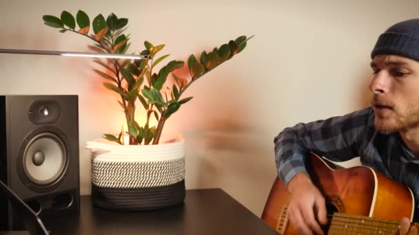Άντρας τραγουδιστής τραγουδάει και παίζει κιθάρα στο σπίτι μπροστά από το laptop, μαθαίνει νέα μουσική σύνθεση — Αρχείο Βίντεο