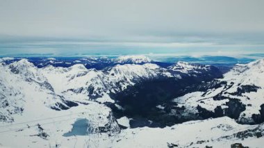 Alp Dağları manzarası. İsviçre 'deki karlı kayalık dağların manzarası. Engelberg kayak merkezindeki dağlar. Kış sporu aktivitesi. Seyahat ve turizm konsepti. Alplerin manzarası