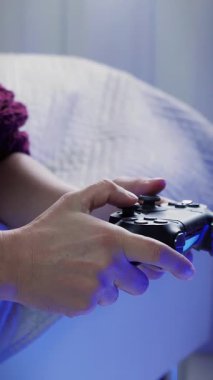 Kadın eller video oyunu kablosuz joystick 'i tutuyor, tuşlara basıyor, kapatıyorlar. Denetleyiciyle video oyunu oynuyor. Dikey video