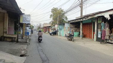 Dükkan ve araçlarla dolu sessiz bir cadde