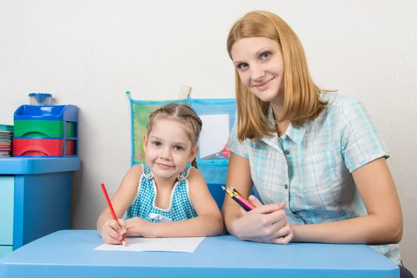 Mentorin und fünfjähriges Kind zeichnen mit Bleistiften am Tisch — Stockfoto