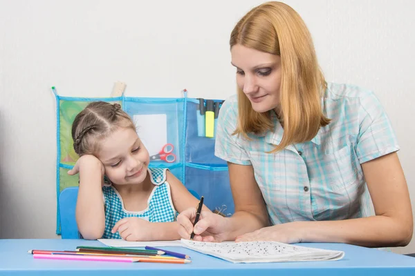 Una joven le explica a la niña de cinco años cómo escribir cartas — Foto de Stock