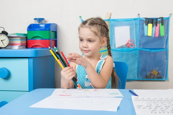 Happy five year old girl picked up a colored pencils and choose the right pencil — Stock Photo, Image