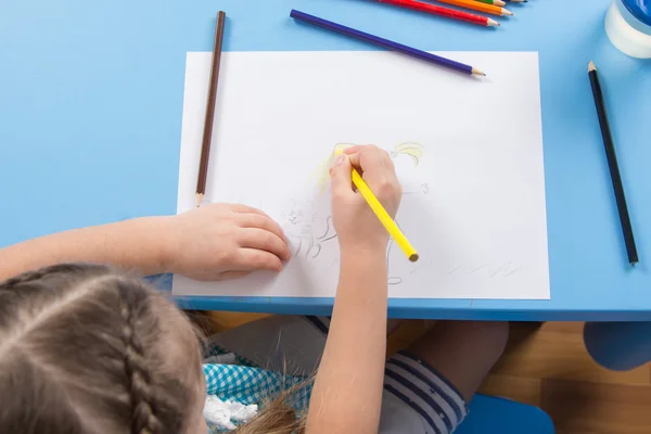 Niña de cinco años dibuja lápiz sobre papel, vista superior —  Fotos de Stock