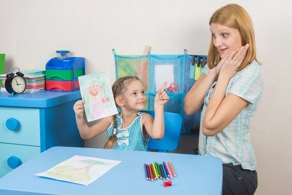 Menina de cinco anos pintou uma mãe e mostra sua mãe surpresa e feliz — Fotografia de Stock