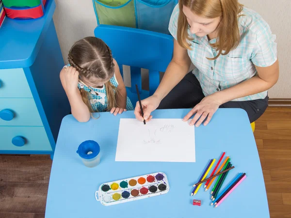 テーブルのメンターと5歳の女の子は幼稚園で絵を描きます — ストック写真