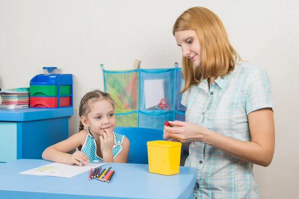 Five-year girl with interest looks like mom sharpens pencils — Stock Photo, Image