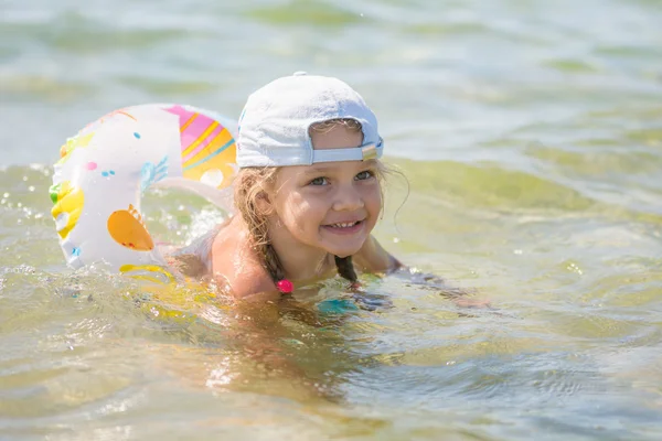 Happy four-year girl floats with a circle in the sea water — Stock Photo, Image