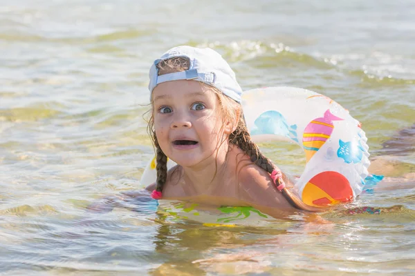 Забавная четырехлетняя девочка плавает с кругом в воде — стоковое фото