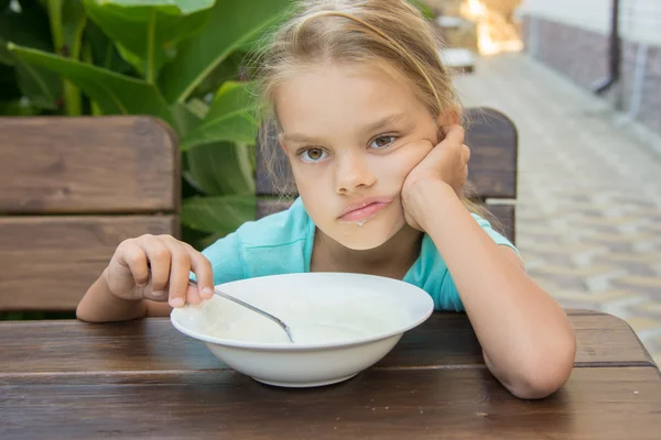 Menina de seis anos não quer comer mingau de cereal no café da manhã — Fotografia de Stock