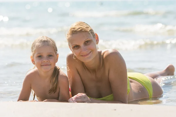 Mom and daughter are in the four-year water on the sandy seafront and joyfully look to the Frame — Stock Photo, Image
