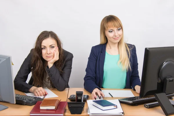 De situatie op kantoor-een vrouw zittend aan een tafel in frustratie, de andere gelukkig kijken naar een computerscherm — Stockfoto