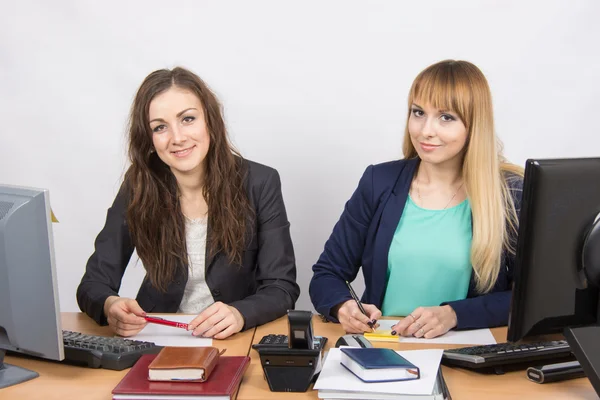 Dos mujeres de negocios sentadas en un escritorio en la oficina —  Fotos de Stock