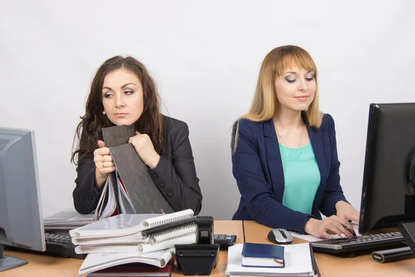 Vrouwelijke collega's in het kantoor, een moe kijken in de monitor, de andere gelukkig werken op een computer — Stockfoto