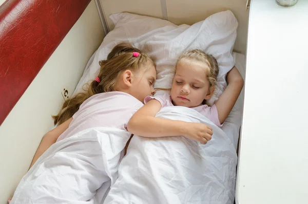 Sisters sleep on a cot in a train — Stock Photo, Image