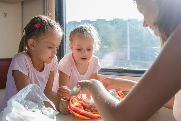 Mi madre desempaca la comida para los niños hambrientos en un vagón de tren de segunda clase — Foto de Stock