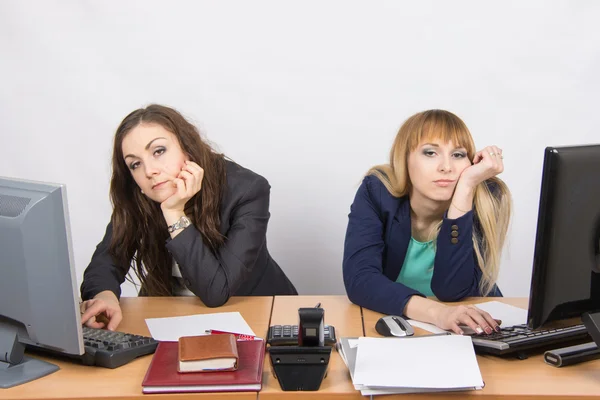 Twee jonge werknemer van het Bureau achter een bureau helaas op zoek naar het frame — Stockfoto