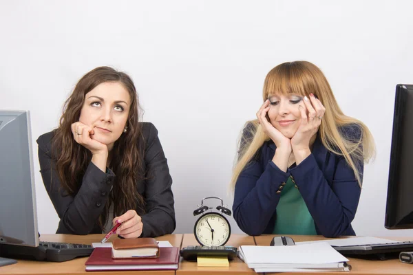 Dos empleados en la oficina esperando el final de las horas de trabajo en el reloj — Foto de Stock