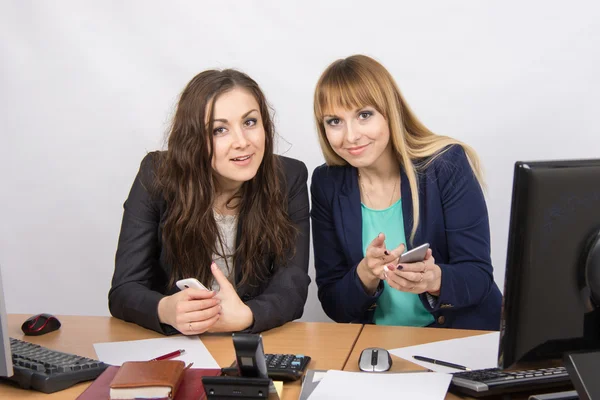 Kontorsanställda diskutera personliga frågor i mobiltelefoner vid sitt skrivbord — Stockfoto