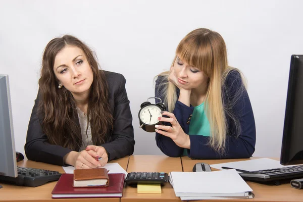 Dos mujeres cansadas en la oficina esperando el final de la jornada laboral —  Fotos de Stock