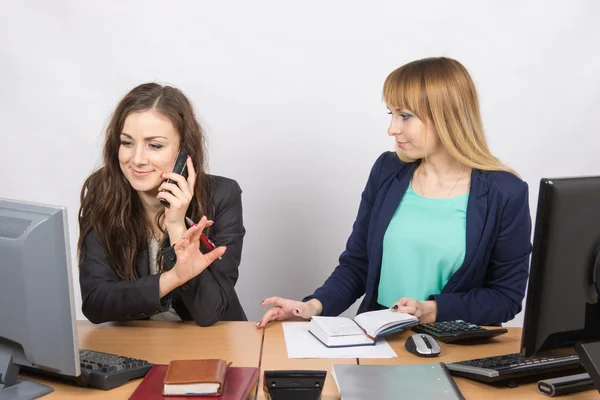 Het meisje in het kantoor praten aan de telefoon vraagt een collega om te wachten — Stockfoto